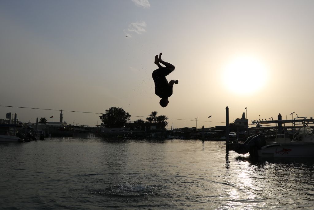 Perfect backflip form over waterline at sunset