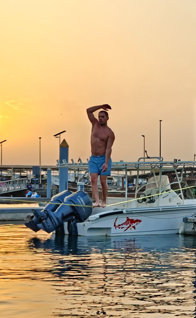 Carlos standing on boat at golden sunset before waterline session